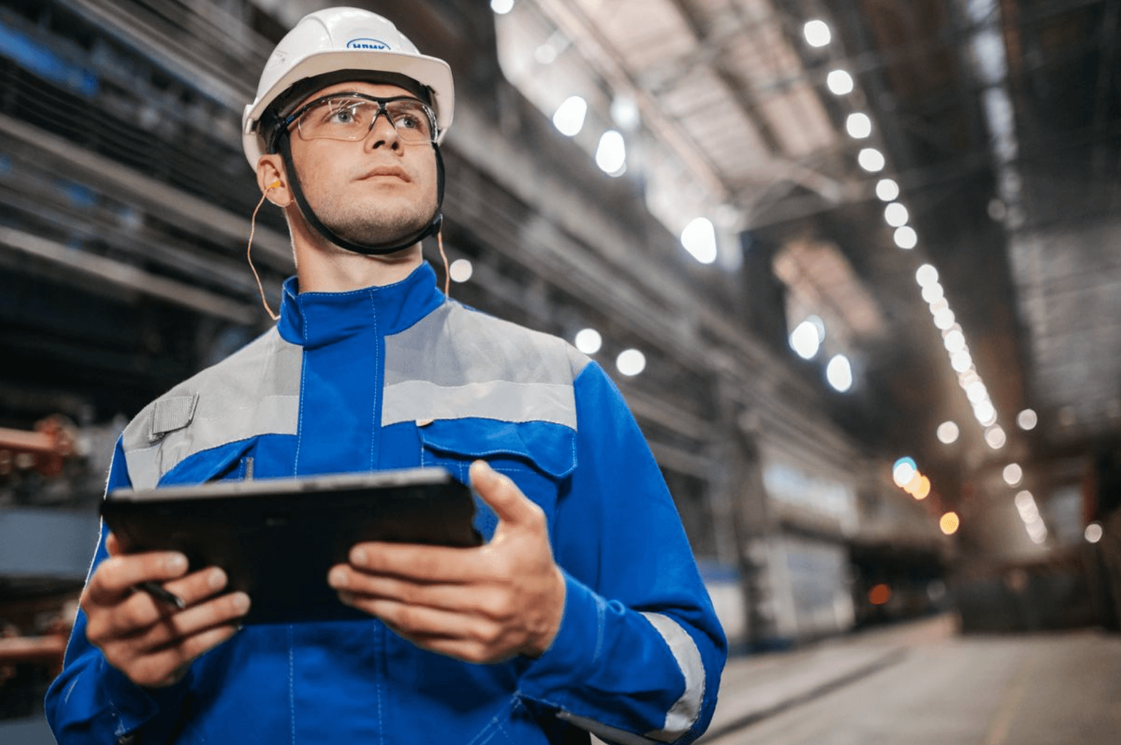 Operador com tablet acompanhando a produção em tempo real no chão de fábrica